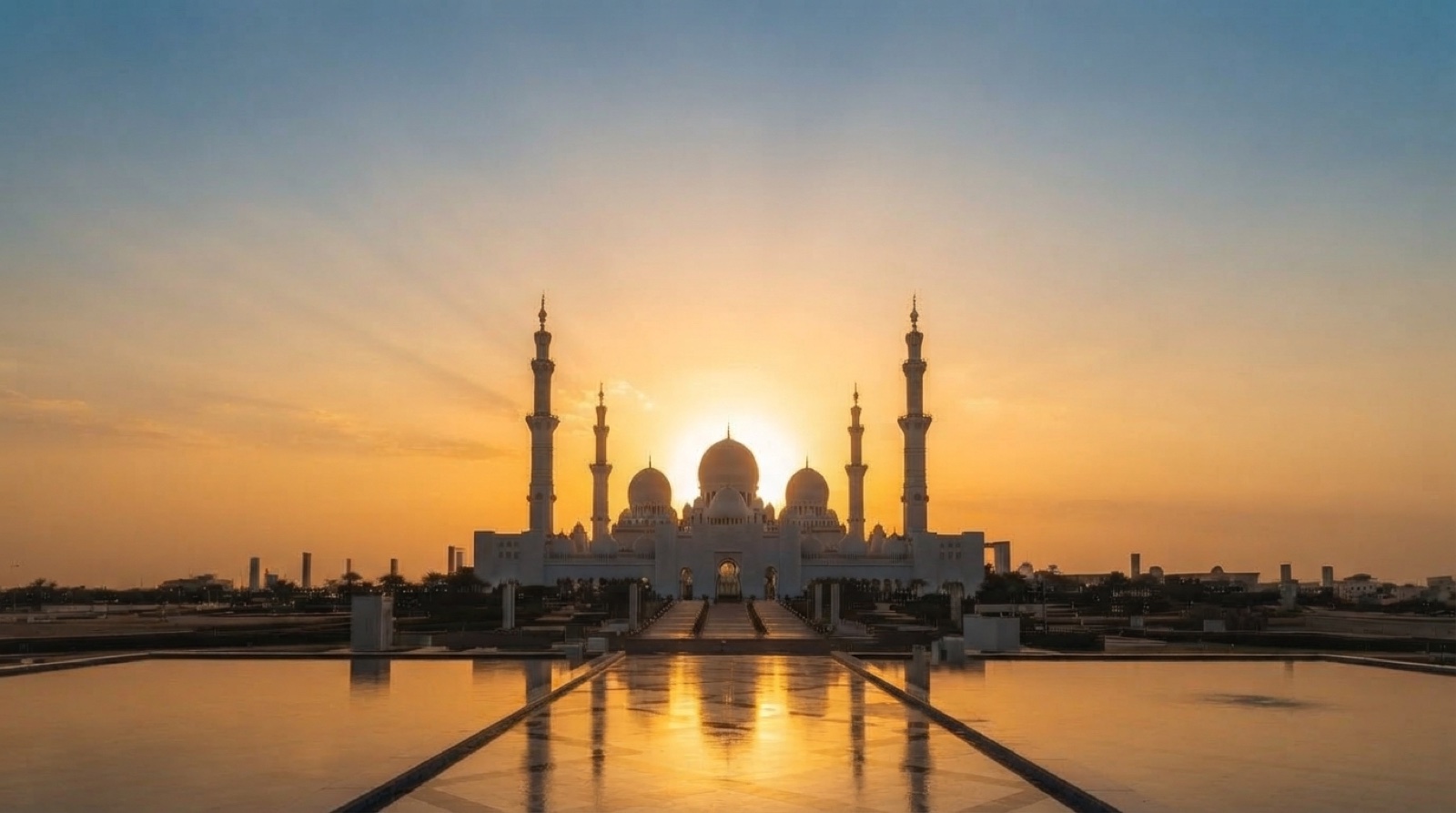 Mosque with the sun bright behind its domes, reflected in still water.